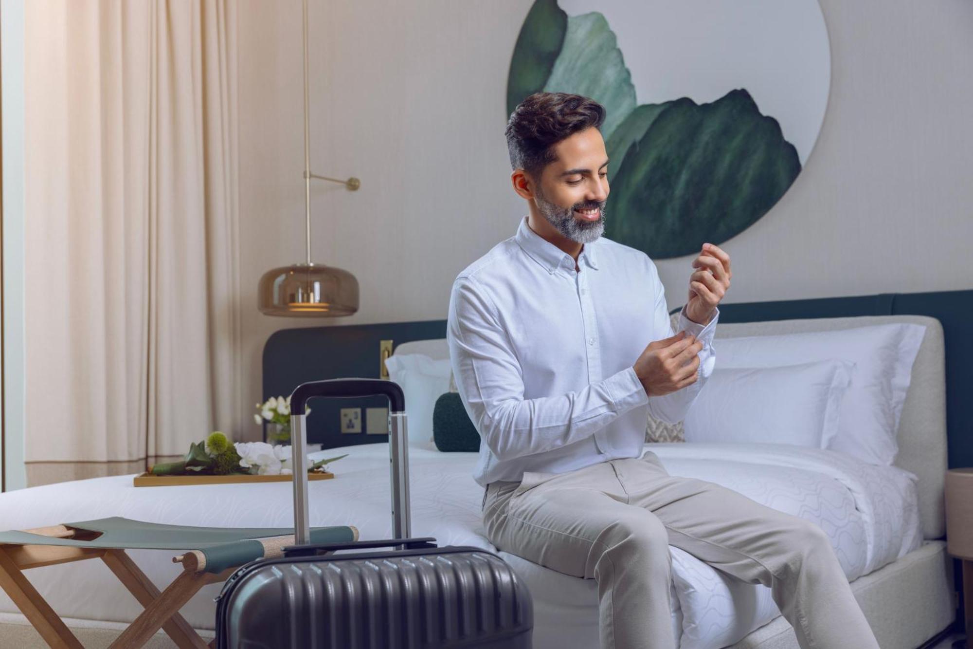 Onyx Rotana Hotel Manama Exterior photo A man using a mobile phone
